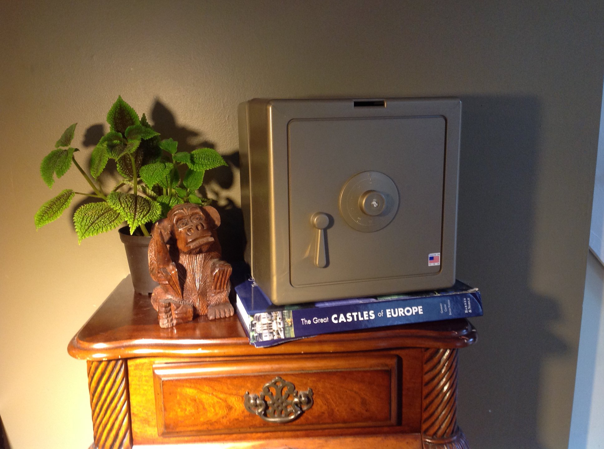 Gold Temptationless Bank beside plant on nightstand